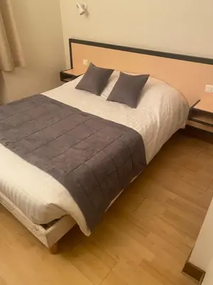 Un ou plusieurs lits dans un hébergement de l'établissement hotel du commerce