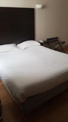 Un ou plusieurs lits dans un hébergement de l'établissement Logis Hôtel des Deux Forts