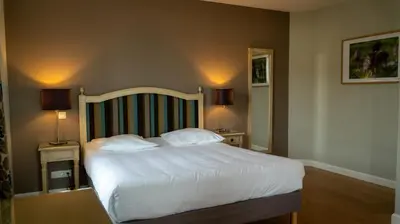 Un ou plusieurs lits dans un hébergement de l'établissement Logis Hôtel L'Orée des Charmes et son restaurant L'évYdenCe