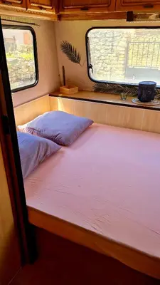 Un ou plusieurs lits dans un hébergement de l'établissement Caravane Zen & Jacuzzi proche des grottes de Bèze