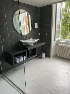 Salle de bains dans l'établissement Hôtel des Cymaises
