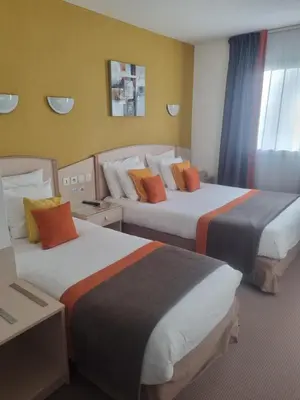 Un ou plusieurs lits dans un hébergement de l'établissement Hôtel Le Kolibri