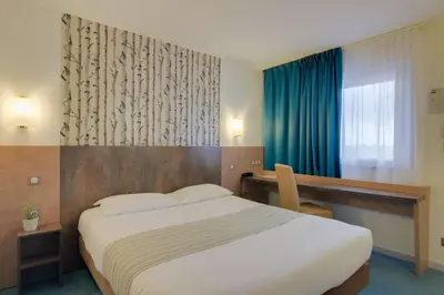 Un ou plusieurs lits dans un hébergement de l'établissement Brit Hotel Dijon Hermes
