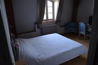 Un ou plusieurs lits dans un hébergement de l'établissement Logis Hotel Domaine du Cheval Blanc