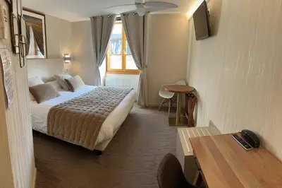 Un ou plusieurs lits dans un hébergement de l'établissement Logis Hôtel des Messageries
