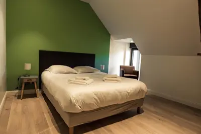 Un ou plusieurs lits dans un hébergement de l'établissement Aux Cortons - Maison avec vue sur le vignoble