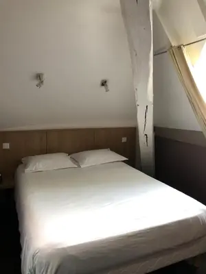 Un ou plusieurs lits dans un hébergement de l'établissement Logis L'Hôtel D'Arc