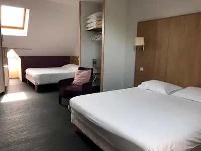 Un ou plusieurs lits dans un hébergement de l'établissement Logis L'Hôtel D'Arc