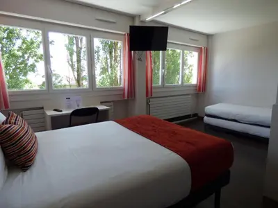 Un ou plusieurs lits dans un hébergement de l'établissement Cit'Hotel Escatel