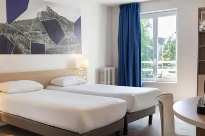 Un ou plusieurs lits dans un hébergement de l'établissement Brit Hotel Mâcon Centre Gare