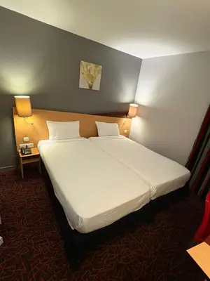 Un ou plusieurs lits dans un hébergement de l'établissement Kyriad Hotel Dijon Gare