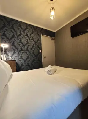 Un ou plusieurs lits dans un hébergement de l'établissement BAR HOTEL DU CENTRE (BDC)