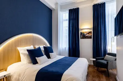 Un ou plusieurs lits dans un hébergement de l'établissement Hotel du Palais Dijon