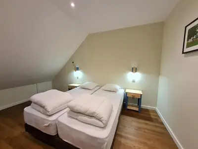 Un ou plusieurs lits dans un hébergement de l'établissement Le Faubourg - Gîte et chambres d'hôte